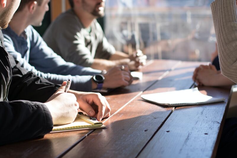 Réunion entre personnes autour d’une table à un salon dédié à l’emploi Réunion entre personnes autour d’une table à un salon dédié à l’emploi